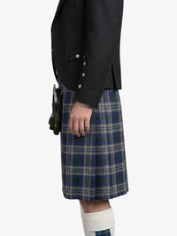 Person wearing a black blazer and blue plaid kilt on a white background