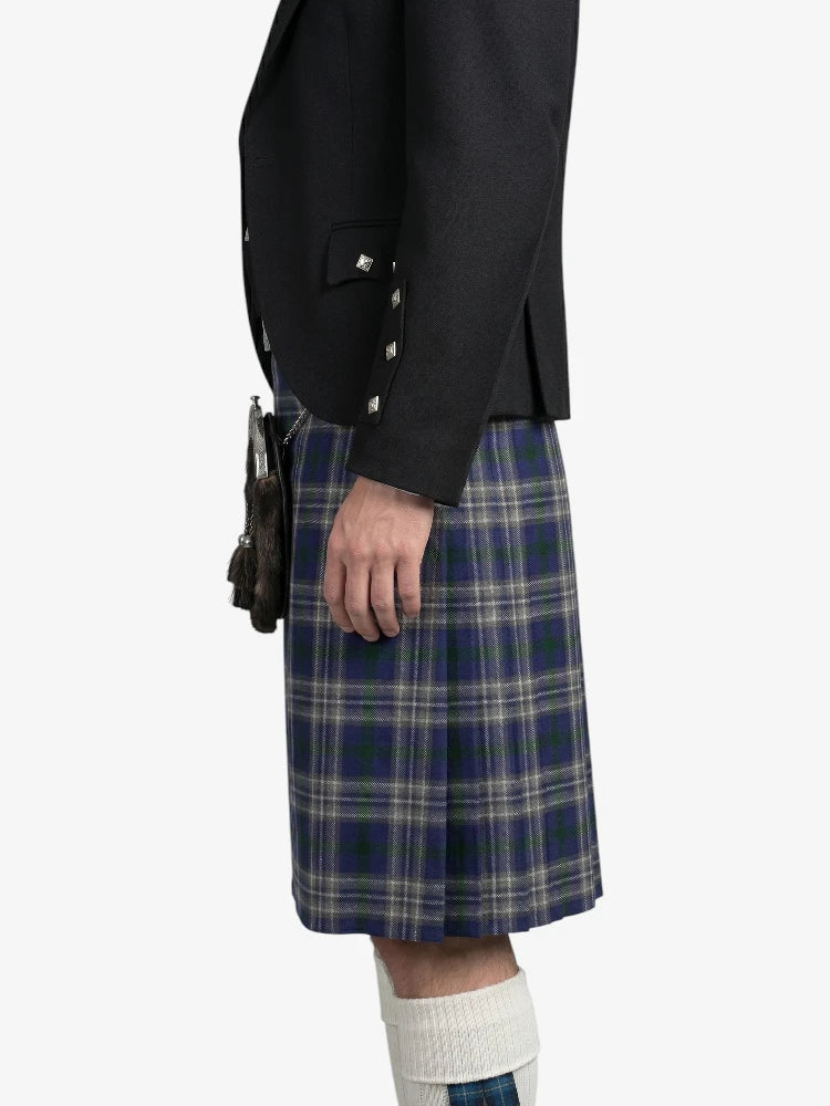 Person wearing a black blazer and blue plaid kilt on a white background