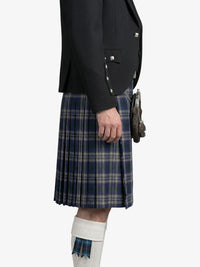 Person wearing a black jacket and blue plaid kilt on a white background