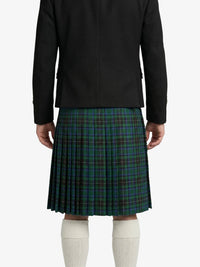 Person wearing a black jacket and green plaid kilt on a white background