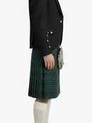 Person wearing a black blazer and plaid kilt on a white background
