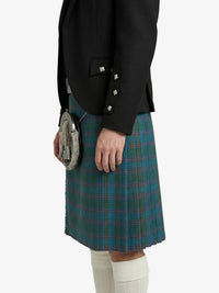 Person wearing a black jacket and green plaid kilt on a white background