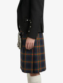 Person wearing a black jacket and plaid kilt on a white background