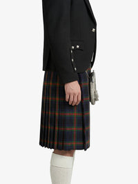 Person wearing a black jacket and plaid kilt on a white background