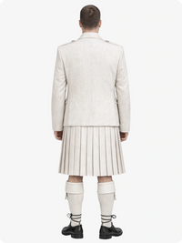 Person wearing a light-colored suit and pleated skirt on a white background