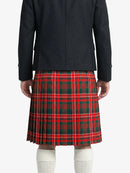 Person wearing a black coat and red plaid kilt on a white background