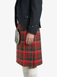 Person wearing a dark jacket and red plaid kilt on a white background