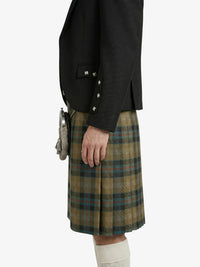 Person wearing a black jacket and plaid kilt on a white background