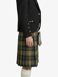 Person wearing a black jacket and plaid kilt on a white background