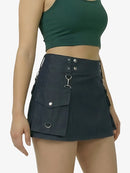 Person wearing a black utility skirt with pockets and silver hardware on a plain background