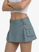 Person wearing a light blue skirt with a white top on a plain background
