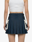 Navy pleated skirt with white accents worn by a person on a plain background
