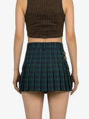 Person wearing a brown crop top and green plaid skirt on a white background